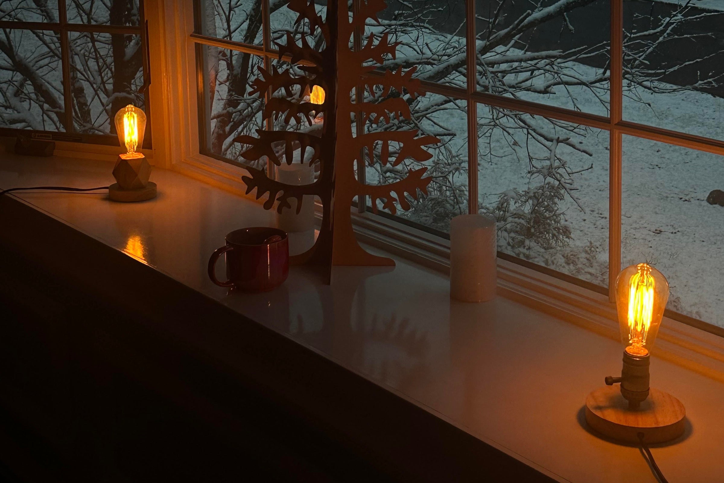 Strainless incandescent bulbs glowing on a windowsill at dusk